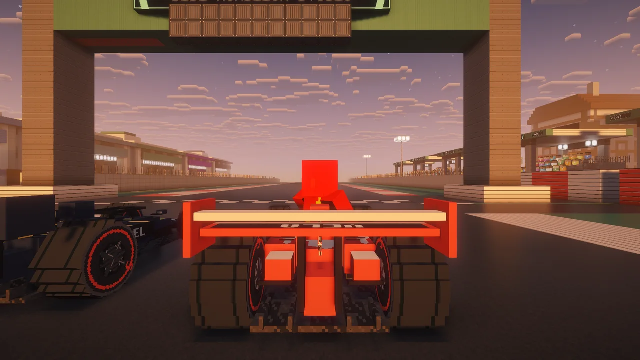 Real in-game screenshot with a shader pack: the red APEX GRID car on the starting grid at golden hour, under the start gantry, grandstands on both sides.